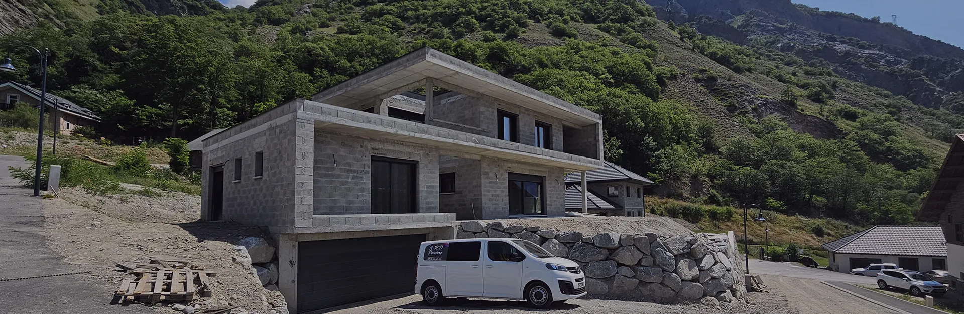 Véhicule utilitaire de l'entreprise A.R.D Peinture devant une maison en construction
